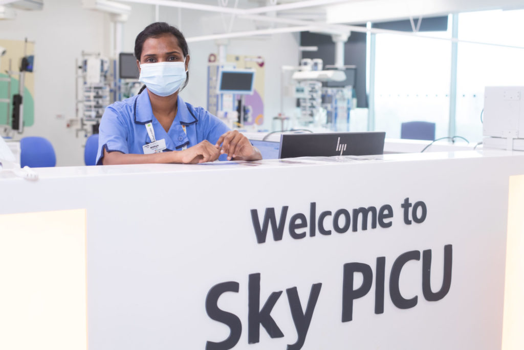 Welcome to Sky PICU desk with staff member in PPE