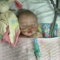 Amelia as a baby in hospital with a tube