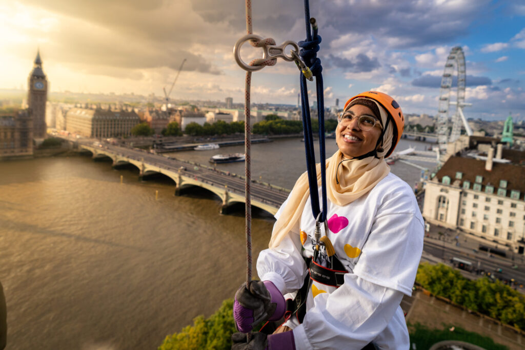 Evelina supporter smiles as they take part in the Abseil