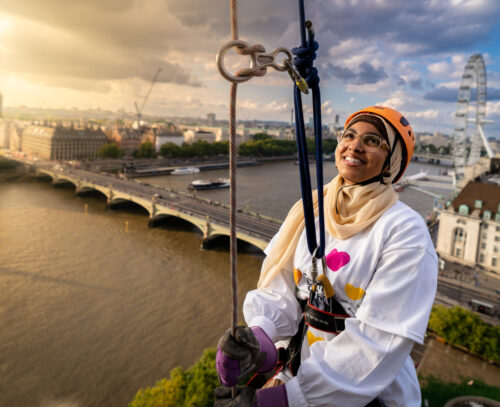 Evelina supporter smiles as they take part in the Abseil