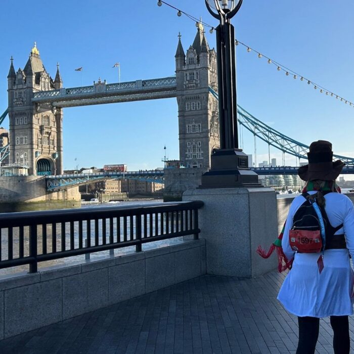 Two ultra challengers walking alongside the river Thames in London, in the background they are walking toward Tower Bridge.