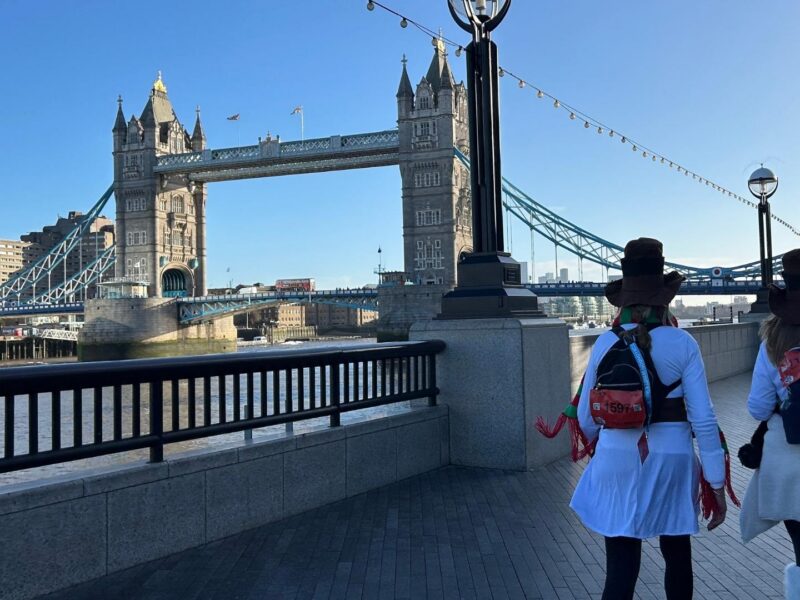 Two ultra challengers walking alongside the river Thames in London, in the background they are walking toward Tower Bridge.