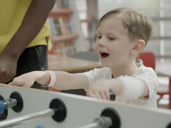 Image of a boy playing table football in the hospital
