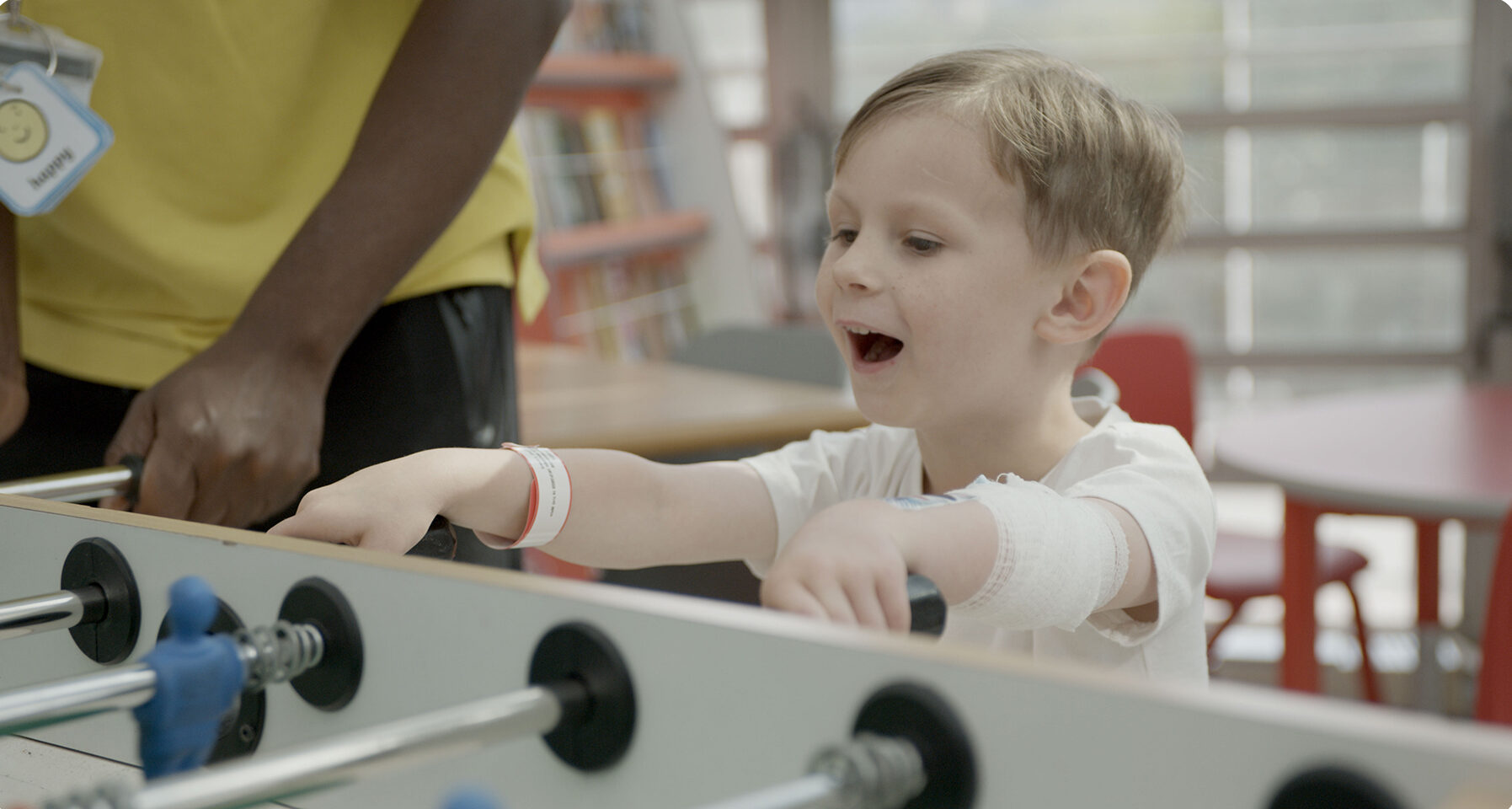 Image of a boy playing table football in the hospital