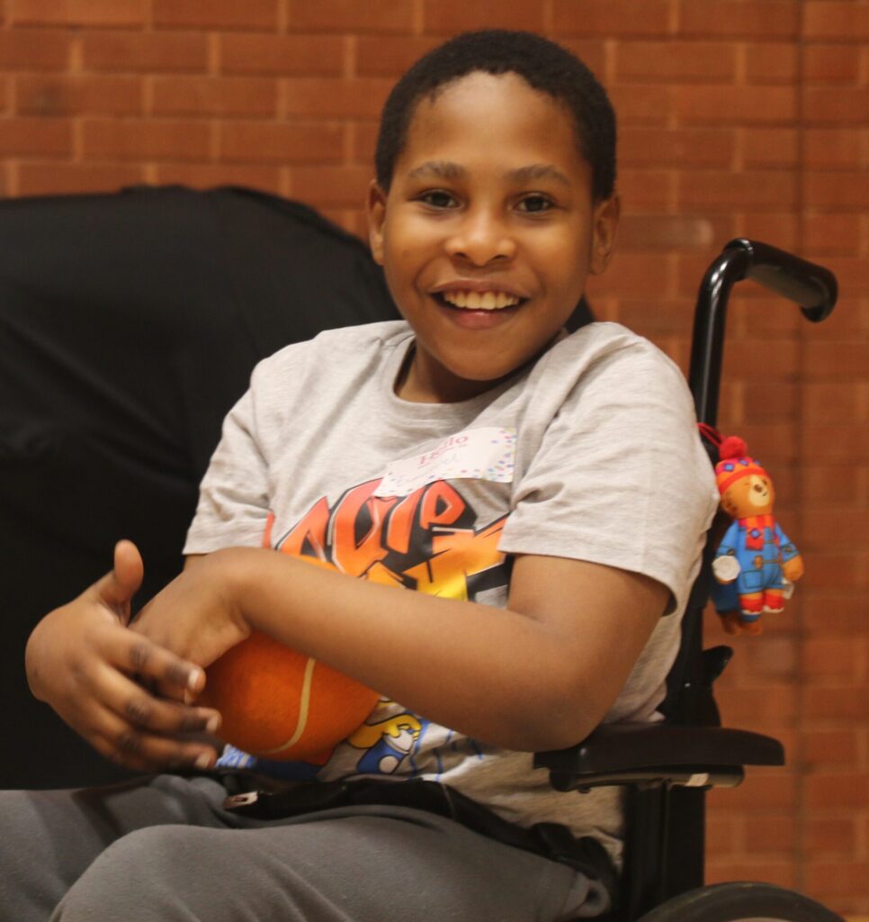 Emmanuel holding an orange basket ball.