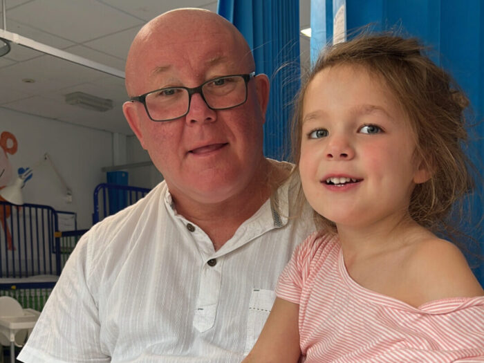 Grandad Paul with Indy on the right in a pink dress at Evelina London Hospital.