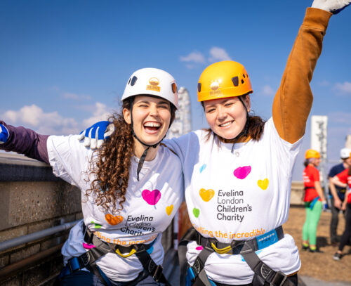 Two women appear to be cheering both wearing Evelina London Children