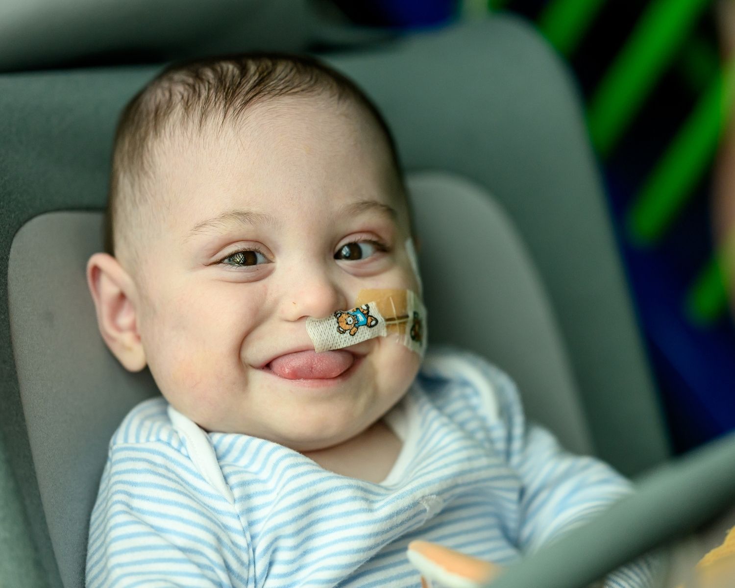 Bertie sat down, smiling with his tongue out a little. In his nostril there is a feeding tube with a colourful plaster.
