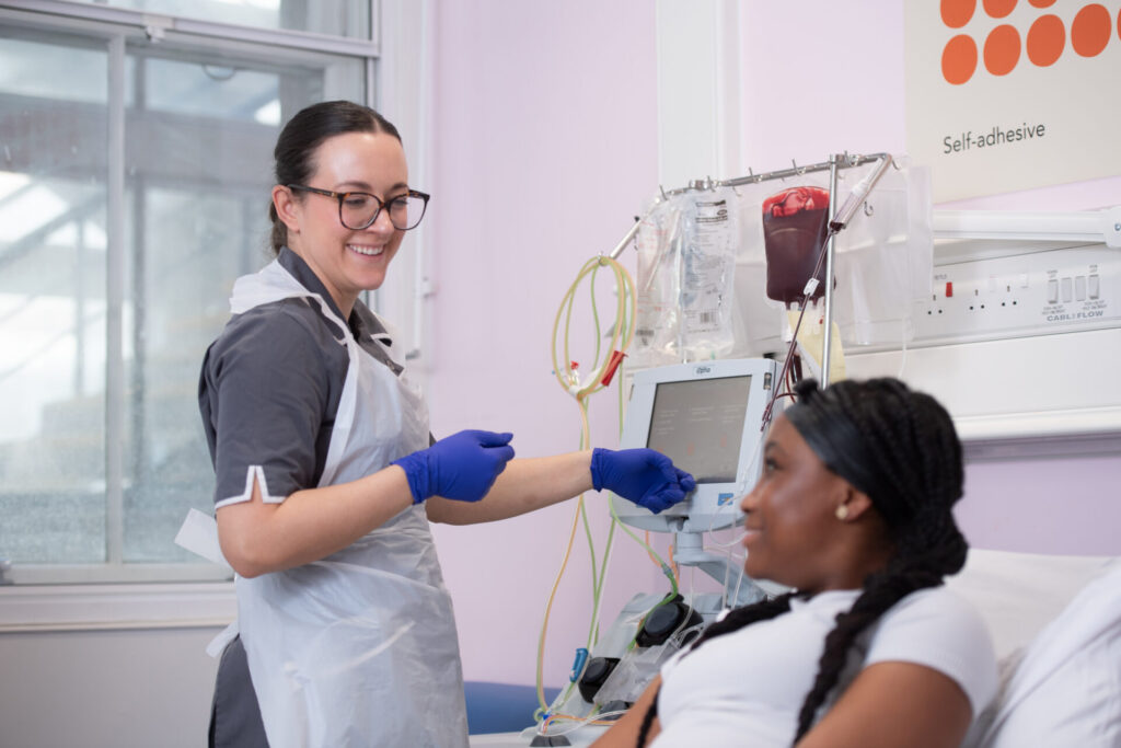 Hannah, a nurse at Evelina London, treating a patient with an apheresis machine